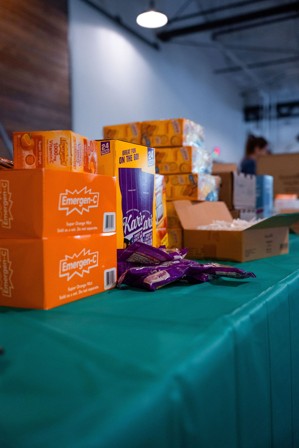 Snack boxes and drink-mix cartons on a packing table at Homeless Heroes Day 2025.