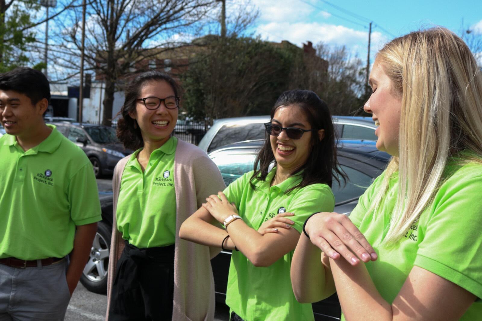 Volunteers in green Backpack Project polos on a distribution day.