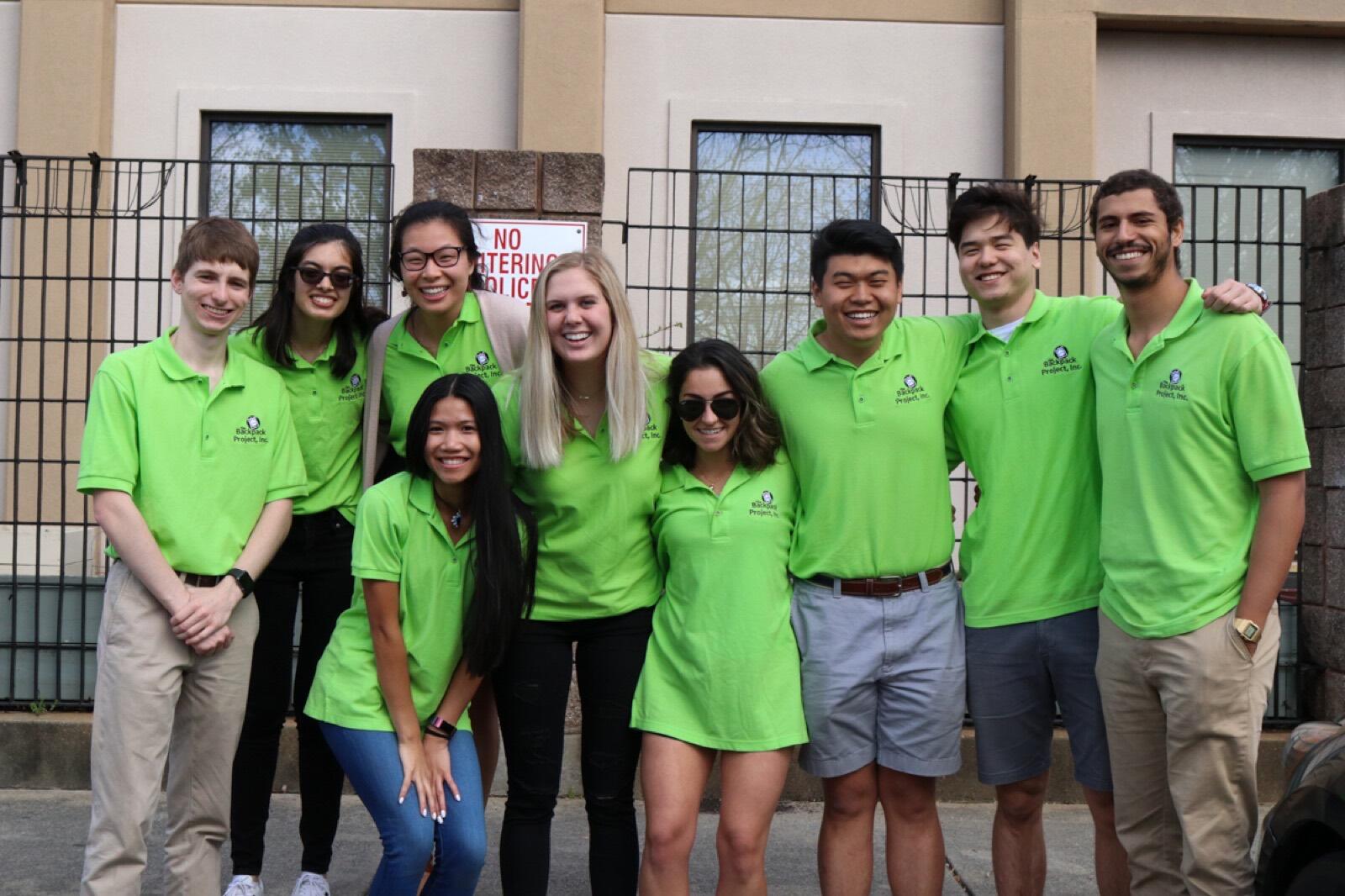 Chapter members in green Backpack Project polos stand together outside.