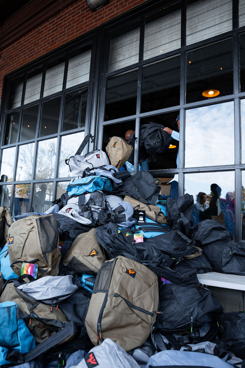 Packed backpacks piled at Westside Warehouse.