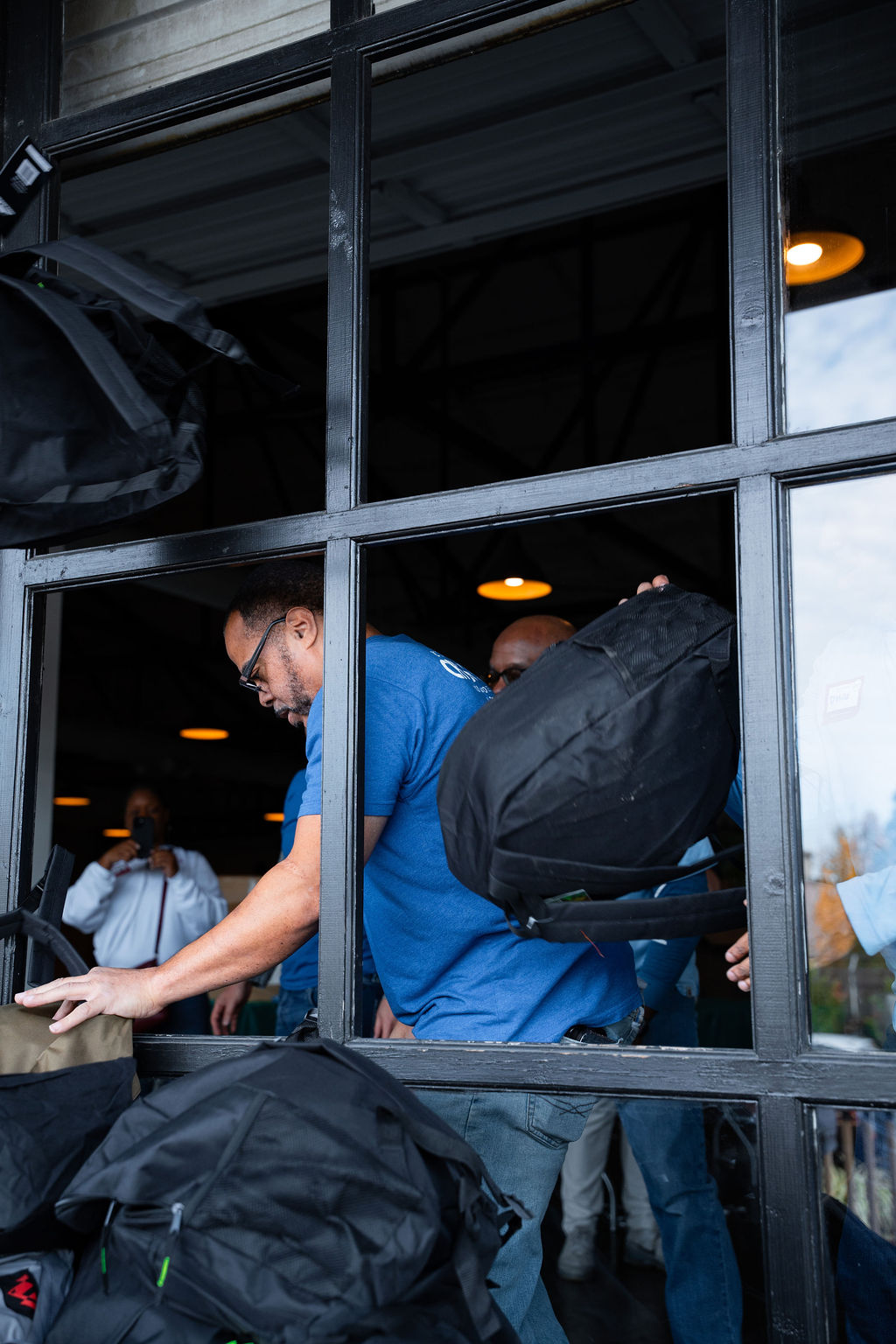 Volunteers move packed backpacks.